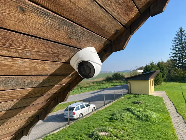 Kamera pod dřevěným podhledem domu