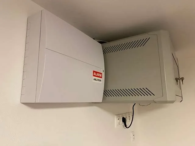 Skříň ústředny alarmu Jablotron vedle datového rozvaděče