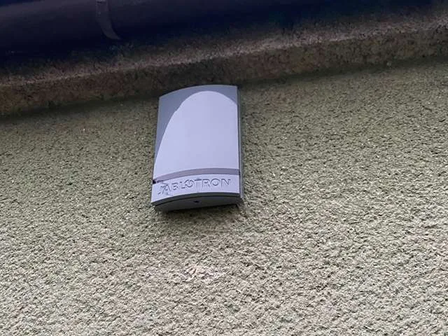 Venkovní siréna Jablotron na fasádě pod střechou