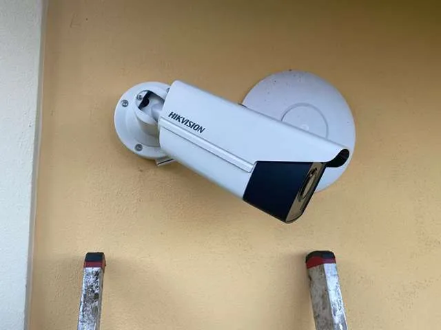 Bílá kamera Hikvision na fasádě domu