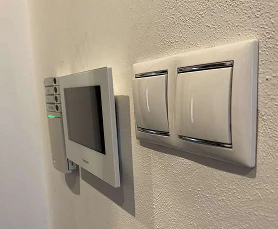 Vnitřní jednotka videotelefonu vedle vypínačů