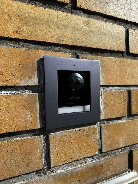 Venkovní stanice videotelefonu Hikvision zapuštěná v cihlové zdi